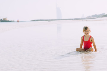 Adorable little girl walking on sandy beach