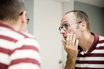 Reflective image of a man looking into a mirror