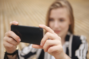 Woman hand taking photo of the city with a smartphone. Close up of woman's hands. Cell phone. Telephone. Mobility and modern lifestyle concept. Beautiful sky. Young Girl Taking Photos Of Landscape