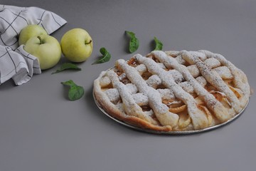 Apple pie with white towel on grey background. Dessert. Homemade cake with apples. Autumn flatlay....