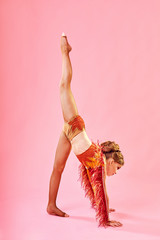 Contemporary dance. A little girl performs a complex acrobatic dance. Modern dance on a bright...