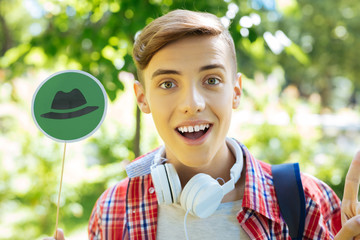 Positive thinking. Progressive blonde-haired smiling student thinking positively with thinking hats