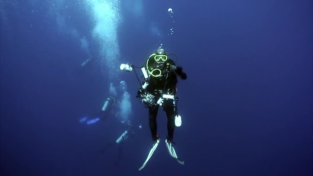Diver movie camera operator makes a video undwewater. Amazing life in blue water. Scuba diving.