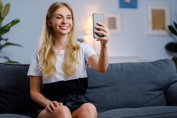 Beautiful woman using her smartphone in the living room
