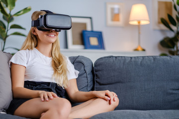 Attractive young woman in VR headset gesturing and smiling