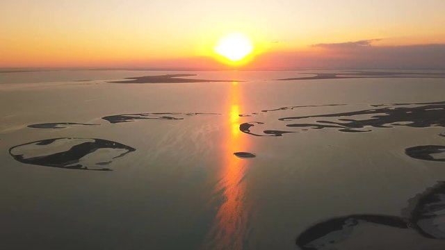 4K  Aerial. Sunset, sunrise   over  sea , ocean with islands .Sunshine red reflection. Rear fly
