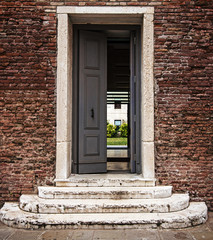 Steps to open door, doorway in old brick wall. Concept: way to the future, new opportunities