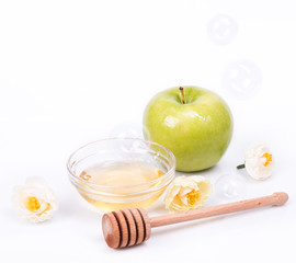 Rosh Hashanah Jewish holiday concept - honey, green apple, white flowers and dipper. traditional holiday symbols