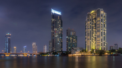 The bright lights of Bangkok's Silom financial district across the river at night