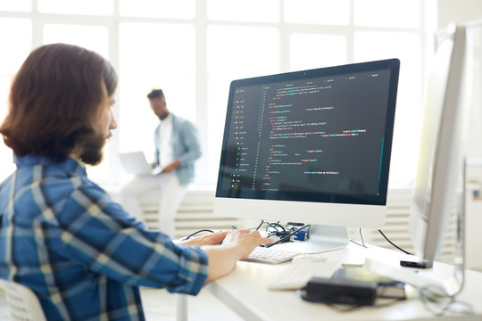 Serious Busy Hipster Young Web Developer Typing On Computer Keyboard While Coding Information In Modern Office