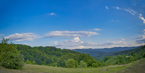 Landscape with green mountain valley with blue sky and white clouds