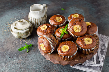 Chocolate muffins with banana on concrete background