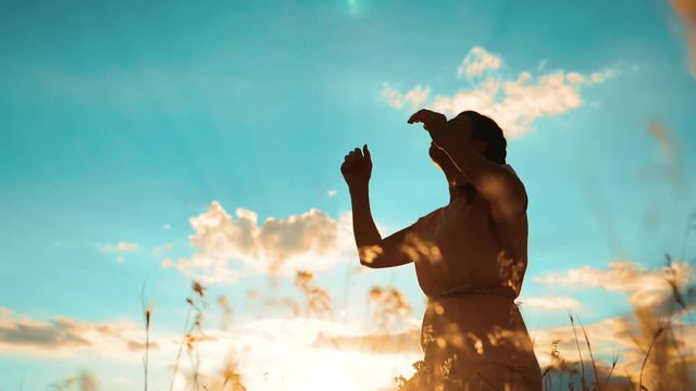 woman praying on her knees. lifestyle Girl folded her hands in prayer silhouette at sunset. slow motion video. Girl folded her hands in prayer pray to God. the girl praying asks forgiveness for sins