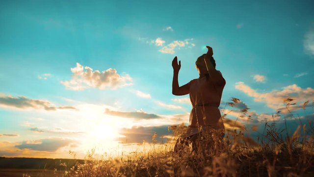 Girl folded her hands in prayer silhouette at sunset. woman praying on her knees. slow motion video. Girl folded her hands in prayer pray to lifestyle God. the girl praying asks forgiveness for sins