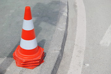 Cones de sinalização arrumados, empilhados uns dentro dos outros e colocados em cima de um passeio