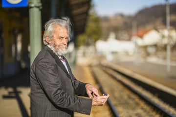 Man with mobile phone and waiting for train - obrazy, fototapety, plakaty
