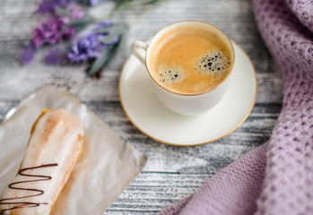 Cup of hot coffee on rustic wooden table, closeup photo warm sweater with mug, winter morning concept, top view