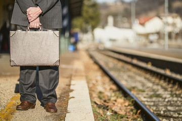 Man with suitcase waiting for her train
