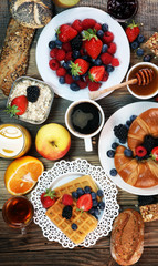 breakfast on table with waffles, croissants, coffe and juice.