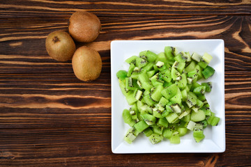 Freshly sliced kiwi fruit with whole kiwis in background.