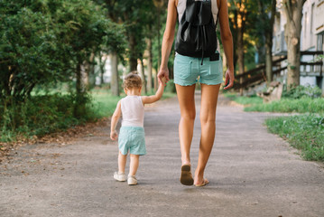 Mother with little daughter walking in the park