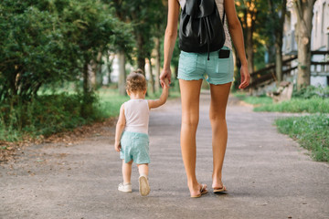 Mother with little daughter walking in the park