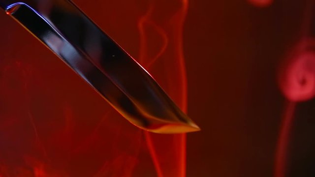 Blade of a knife close-up on a red background. Steel arms, Dagger. Blade close-up