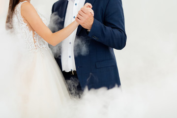 First dance at the wedding. Pair dancing in the fog, holding hands