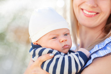 Mother holding a newborn baby in her arms, family portrait.