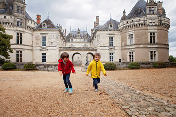 Two children, playing in the rain in front of the Le Lude castle © Tomsickova