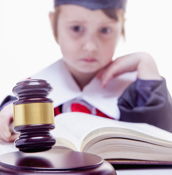 Theories on judicial decision concept. Portrait of serious child girl judge (lawyer) makes a decision. Humorous photo.