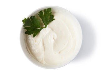 Cream cheese in a bowl, isolated on white background, top view.