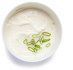 Cream cheese in a bowl, isolated on white background, top view.
