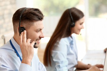 Technical support operators with headsets at workplace