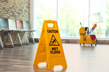 Safety sign with phrase Caution wet floor, indoors