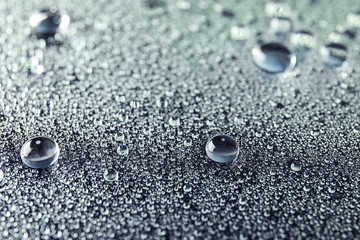 Many clean water drops on dark background