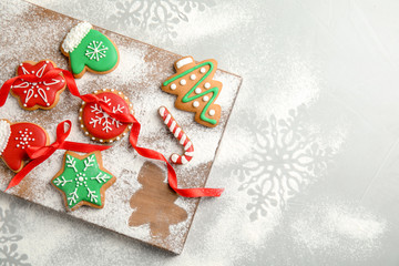 Tasty decorated Christmas cookies on wooden board, top view