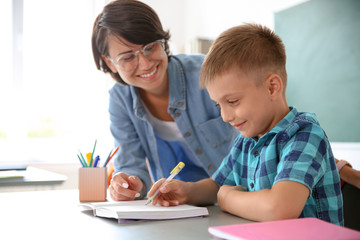 Female teacher helping child with assignment at school