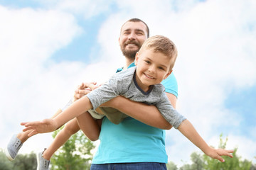 Obraz premium Man playing with his child outdoors. Happy family