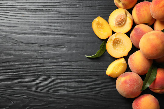 Flat lay composition with ripe peaches on wooden background