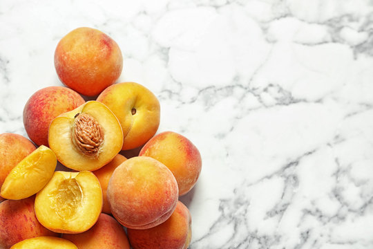 Pile of delicious ripe peaches on marble background, top view