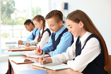 Teenage students in classroom. Stylish school uniform