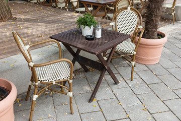Street cafe is waiting for guests. Empty chairs and table in summer