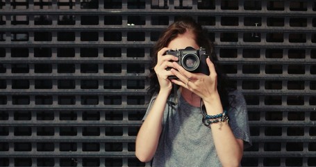 Portrait of pretty young woman with vintage camera takes photo of you