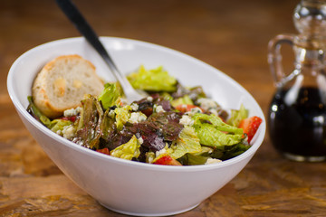Ensalada de la casa con queso en tazón blanco
