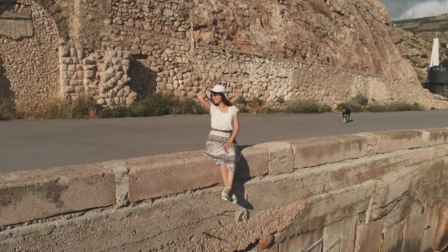 Woman sitting and smiling on parapet
