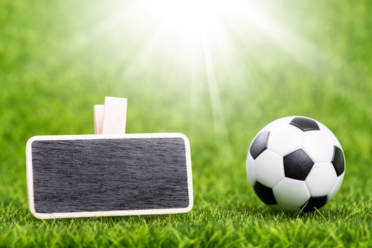 Soccer ball and mockup board on green grass