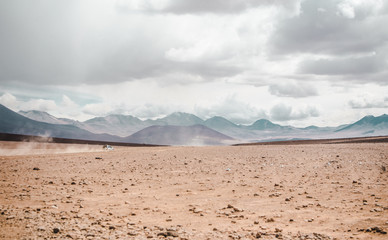 Fototapeta na wymiar 4x4 cars speeding off into the desert over the Chile border into Bolivia
