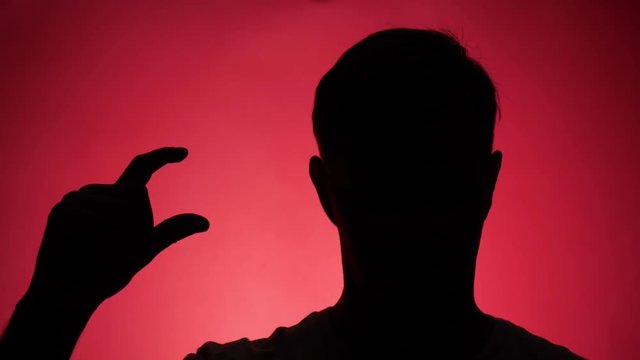 color background. 4k, slow motion. shadow of a man. man shows gesture little