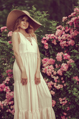 portrait Happy smiling Beautiful young woman posing near flowers in a garden.